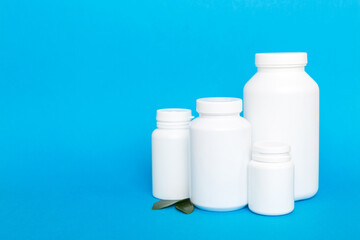 supplement pills with medicine bottle health care and medical top view. Vitamin tablets. Top view mockup bottle for pills and vitamins with green leaves, natural organic bio supplement, copy space