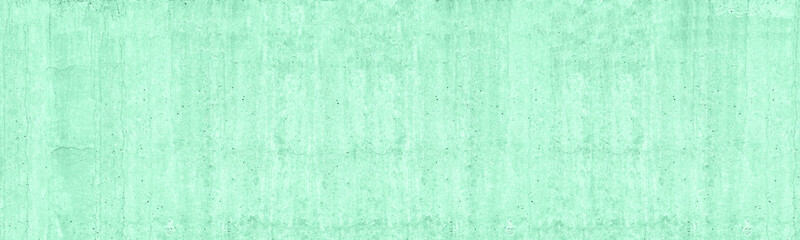Fototapeta na wymiar Pastel green mint painted old concrete wall. Rough messy cement slab wide texture. Panoramic pale aquamarine grunge background