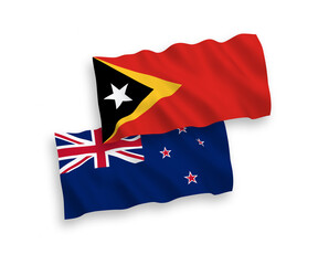 National vector fabric wave flags of New Zealand and East Timor isolated on white background. 1 to 2 proportion.