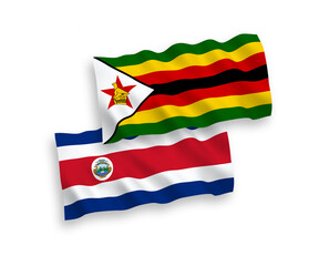 National vector fabric wave flags of Republic of Costa Rica and Zimbabwe isolated on white background. 1 to 2 proportion.