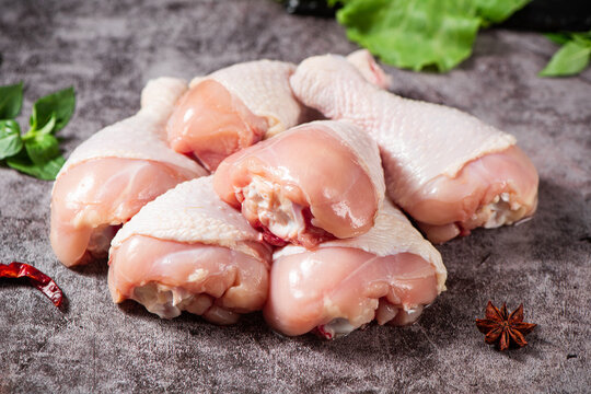 Raw chicken drumsticks with seasonings on table