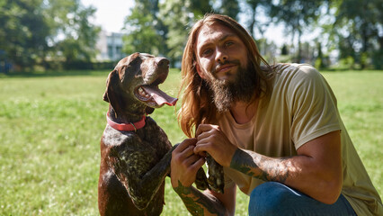 Man posing with Kurzhaar dog and looking at camera