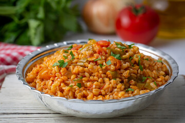 Traditional turkish bulgur pilaf with tomato sause in plate (Turkish name; meyhane pilavi)