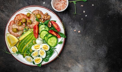 shrimps, prawns, soft fried egg, fresh salad, tomatoes, cucumbers and avocado on a light background. Ketogenic diet breakfast. Keto, paleo lunch. Top view