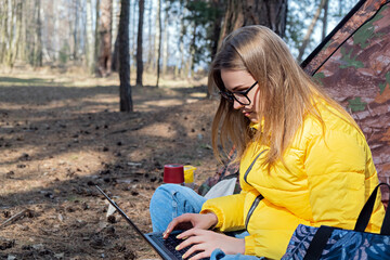 Distance learning online education and work. Woman girl working office work remotely from forest...