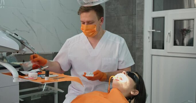 modern dentistry, professional stomatologist chooses special tools to work with patient during treatment and cleaning teeth in dental clinic