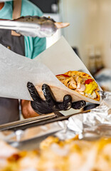 process of preparing traditional greek fast food - gyros. chef hand cooking food