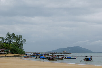 Fototapeta na wymiar Group of long- tail boats of fishermen inhabiting the west coast of Thailand, anchor and run ground on the beach to escape a storm. 