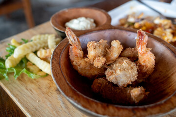 top view of deep fried crispy shrimps and fried potatoes on side. 