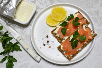 sanwiches with pink salmon and ricotta on white plate, top view