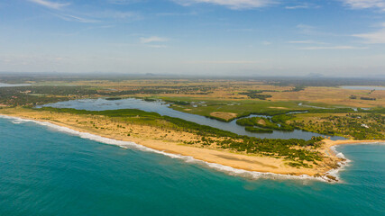 View from the sea to the coastline of Sri Lanka with the beach, river and agricultural land. Whiskey point, Sri Lanka.