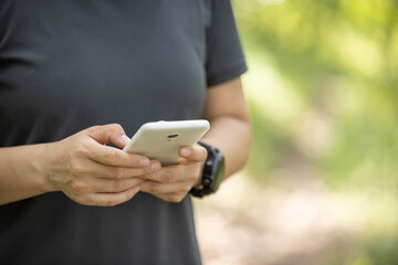 Hands using mobile phone  in summer forest
