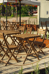 Fototapeta na wymiar cozy summer cafe in the open air. Wooden table and chairs on the terrace