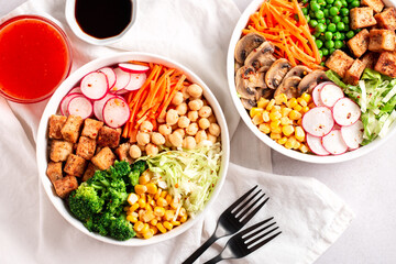 Vegan buddha bowl with tofu, colorful vegetables on base of brown rice.