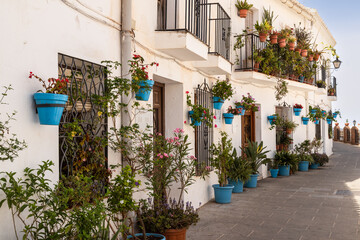 White painted houses with the famous blue flower pots against the wall, in the beautiful mountain...