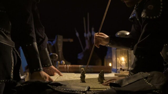 Making a battle plan by candlelight. Analyzing on the map inside the tent in the middle of the war.