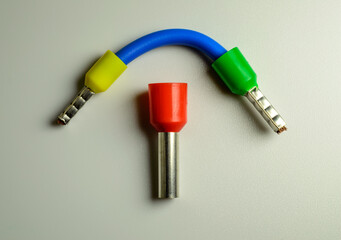 Blue cable with yellow and green ferrules and big red ferrule in the middle of composition.