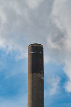Smoke Stack against a blur sky with coke ovens emissions in the background.