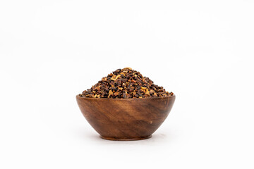Indigofera or indigo seeds in wooden bowl isolated on white background