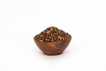 Indigofera or indigo seeds in wooden bowl isolated on white background