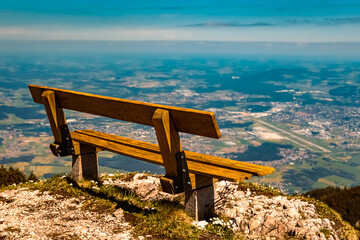 Details of a wooden bench and the far away city of Salzburg at the famous Untersberg mountain,...