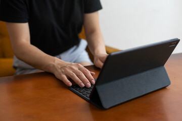 Lets check my timetable. Cheerful young beautiful woman using her touchpad with smile while sitting at her working place