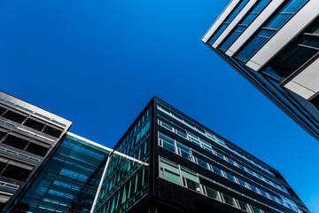 Looking up tall and modern office buildings in concrete glass and steel.