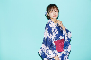 浴衣を着た若い女性の青背景のポートレート