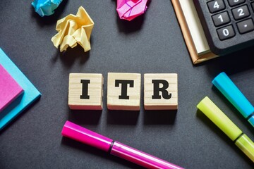 Wooden blocks with the inscription ITR (income tax return) on office desk. 