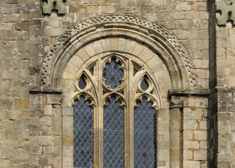 Fototapeta na wymiar Cathedral of Winchester. Detail of Romanesque window with Gothic tracery in the crossing facade. England. United Kingdom.