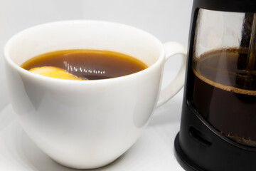a cup of hot filtered coffee, steams rising from cup, standing on a wooden antique table, top shot