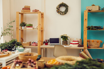 Modern interior of cozy eco gift wrapping studio with Christmas decorations on wooden shelves and tables