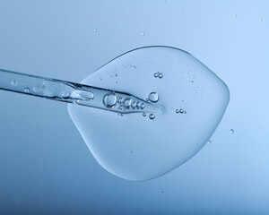 Pipette with bubbles and clear formulation being expelled. Clear liquid with bubbles resembling glycerin, hyaluronic acid or keratin in laboratory or scientific setting.  - obrazy, fototapety, plakaty