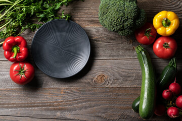 Very fresh vegetables exposed on the cintage wooden table with decorative platter.