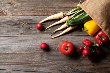 Beautiful fresh vegetables such us tomatoes, radish, parsley, brocoli and pepper straight from grocery farm shop in the reusable eco shopping bag.