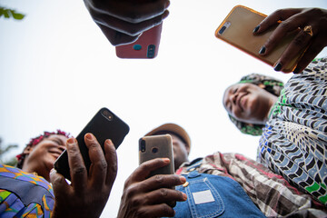 A group of african people use their smartphones, photos from below, technology and social networks in africa. - obrazy, fototapety, plakaty