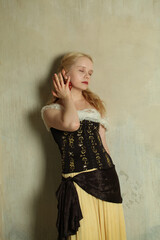 Romantic young woman in vintage retro dress on stucco background