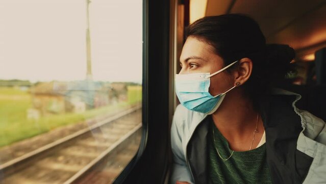 Person travels by train wearing covid face mask during coronavirus pandemic