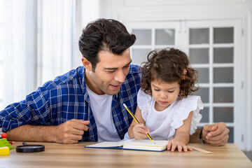 Caucasian handsome man father teach cute young preschool Caucasian child girl daughter to draw and...