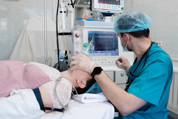 Anesthetist observes the monitor on the ventilator while the patient is being anesthetized. ...