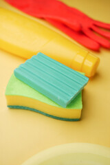 sponge , rubber gloves and colorful plate on pink 