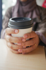 women holding a take away paper coffee cup 