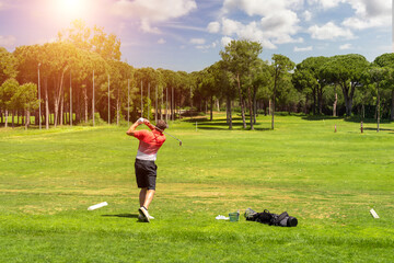Golf player exercising on golf driving range before golf tournament