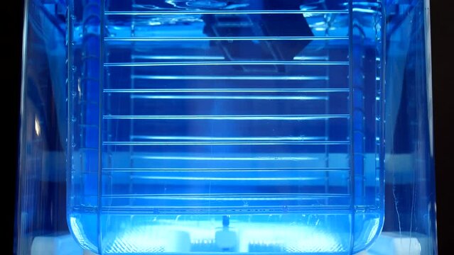 Three dimensional printing post-processing. Close up of circulating water container with printed 3D plastic object floating inside. Moving water removing, dissolving PVA, polyvinyl alcohol residues.