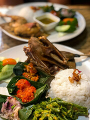 Fried duck or bebek goreng with rice, chilli sauce, vegetables and traditional condiment