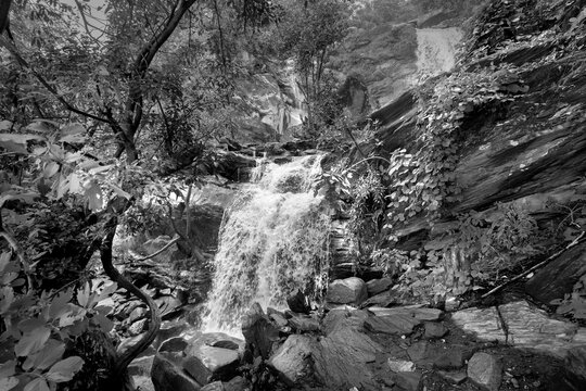 Beautiful Bamni waterfall having full streams of water flowing downhill amongst stones , duriing monsoon due to rain at Ayodhya pahar (hill) - at Purulia, West Bengal, India. Black and White image.