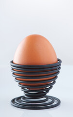 One boiled egg in a spiral-shaped black metal support