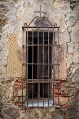 Fototapeta na wymiar Old window with bars and cross.