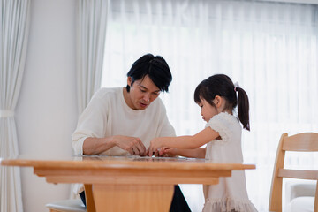パパと一緒にパズルゲームをする小さな女の子