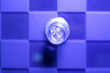 Chess with game pieces made of glass, queen, king, pawn and game board made of glass in black and...